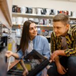 Couple choosing electric oven in electronics store